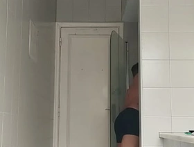 Sexy guy in black beach shorts shaving