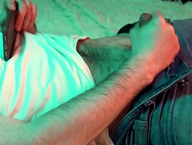 a young hot guy watches porn on his phone and jerks off his small cock.